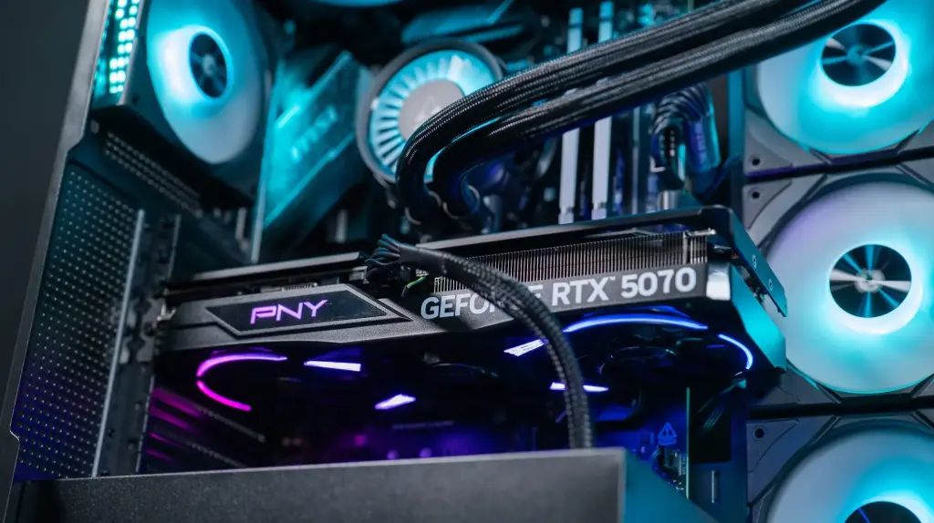Carte graphique GeForce RTX 5070 PNY installée dans un PC gamer RGB avec watercooling et ventilateurs lumineux haute performance