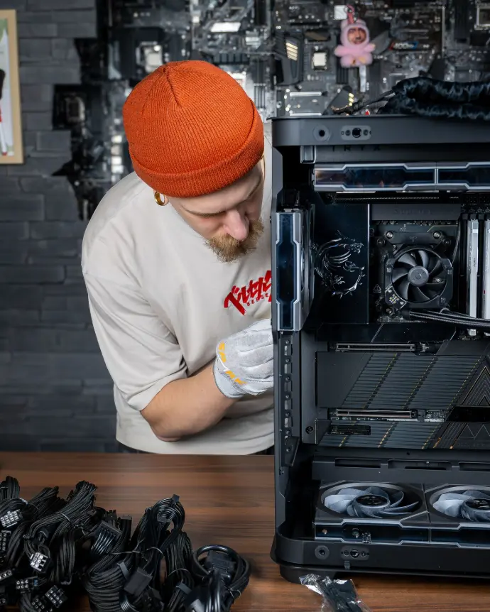 Technicien assemblant un PC gaming avec composants MSI dans un boîtier ouvert pour configuration sur mesure et montage professionnel