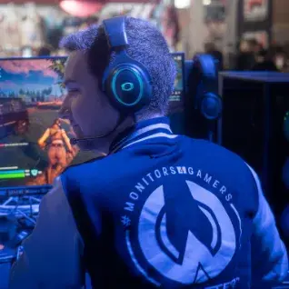 Joueur portant un casque gaming en train de jouer à Fortnite sur PC lors d’un événement gaming