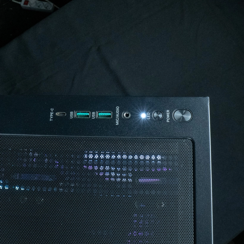 Vue de dessus du panneau de contrôle du PC gamer Cheetoh Remastered avec ports USB, Type-C, bouton LED et bouton d'alimentation