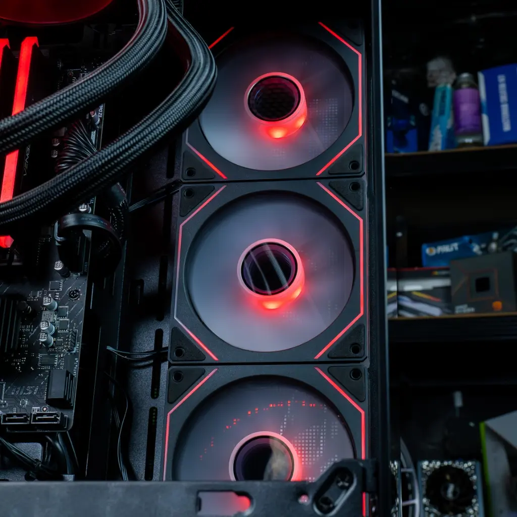 Vue rapprochée des trois ventilateurs de façade avec liseré lumineux ARGB rouge, assurant un flux d'air constant dans le boîtier aquarium du PC Banger